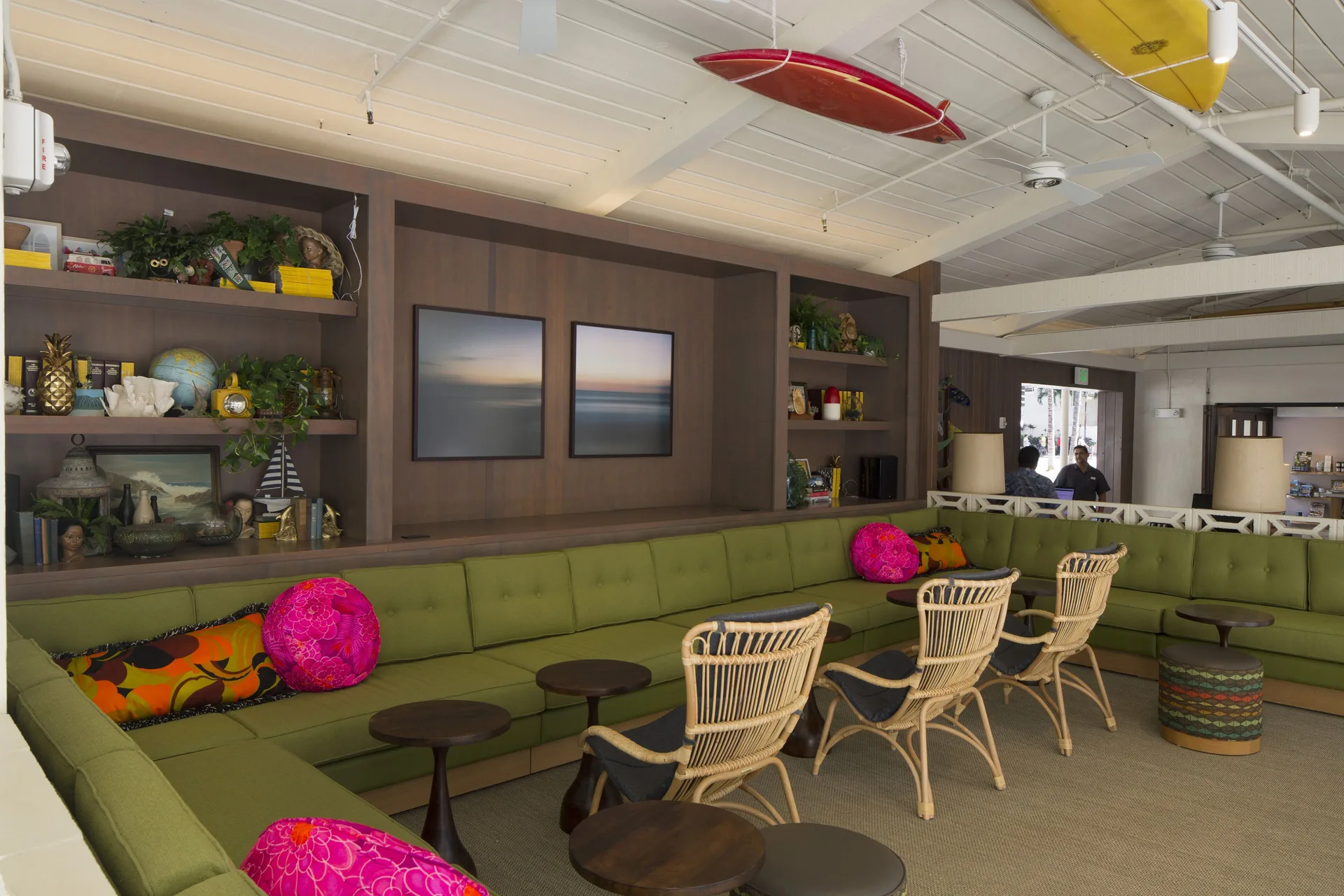 Green banquette lounge with rattan chairs and ceiling surfboards at Surfjack Hotel & Swim Club.