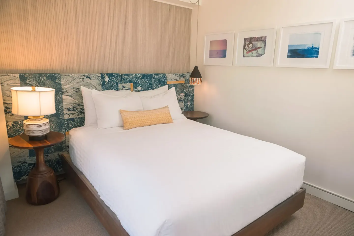 Guest room with one bed and framed wall art at Surfjack Hotel & Swim Club.