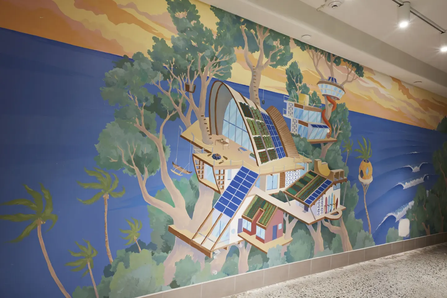 Large illustrated wall mural of tree houses and ocean scenery at Surfjack Hotel & Swim Club.