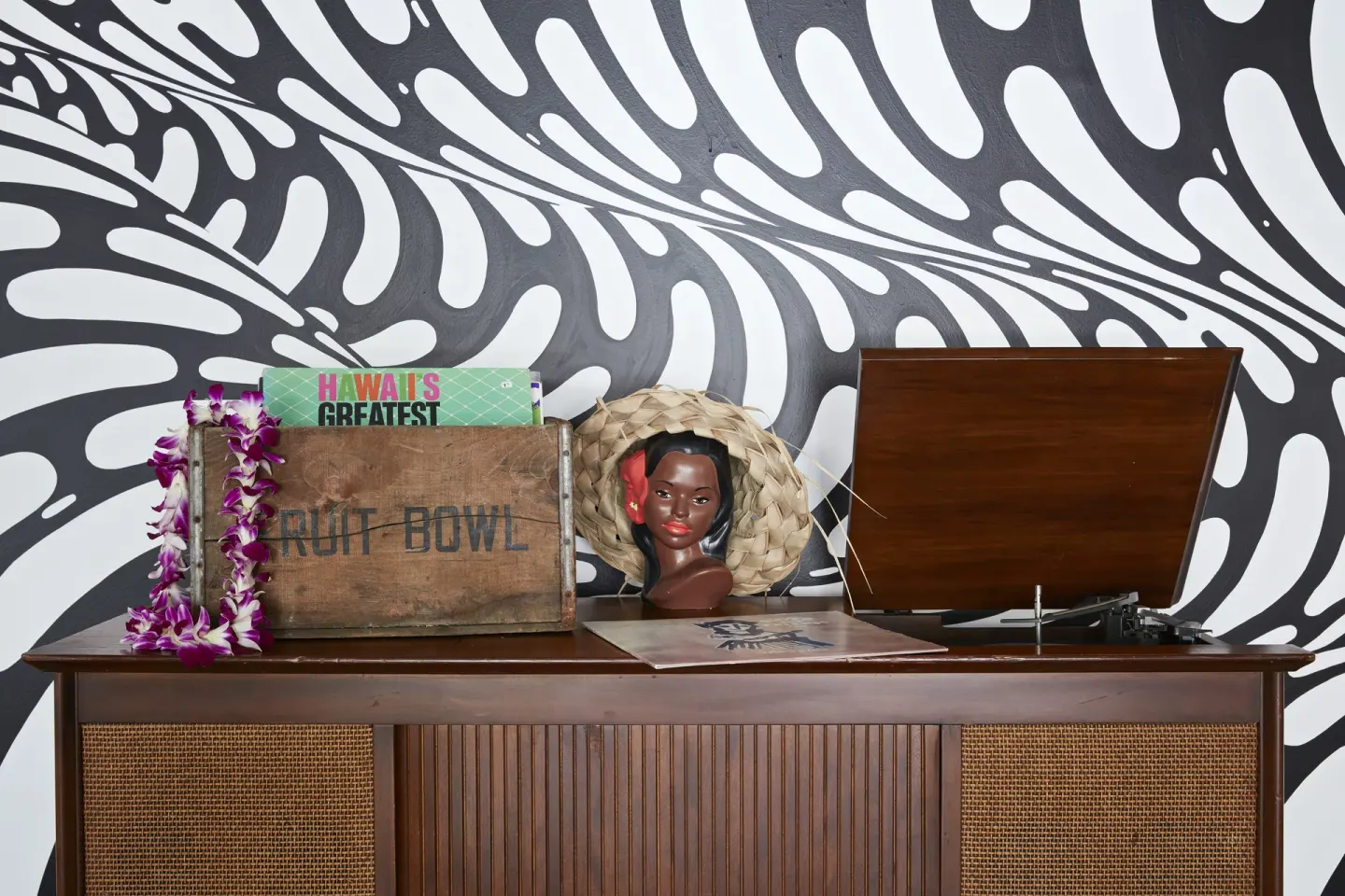 Record player and vintage decor beneath a black-and-white mural at Surfjack Hotel & Swim Club.