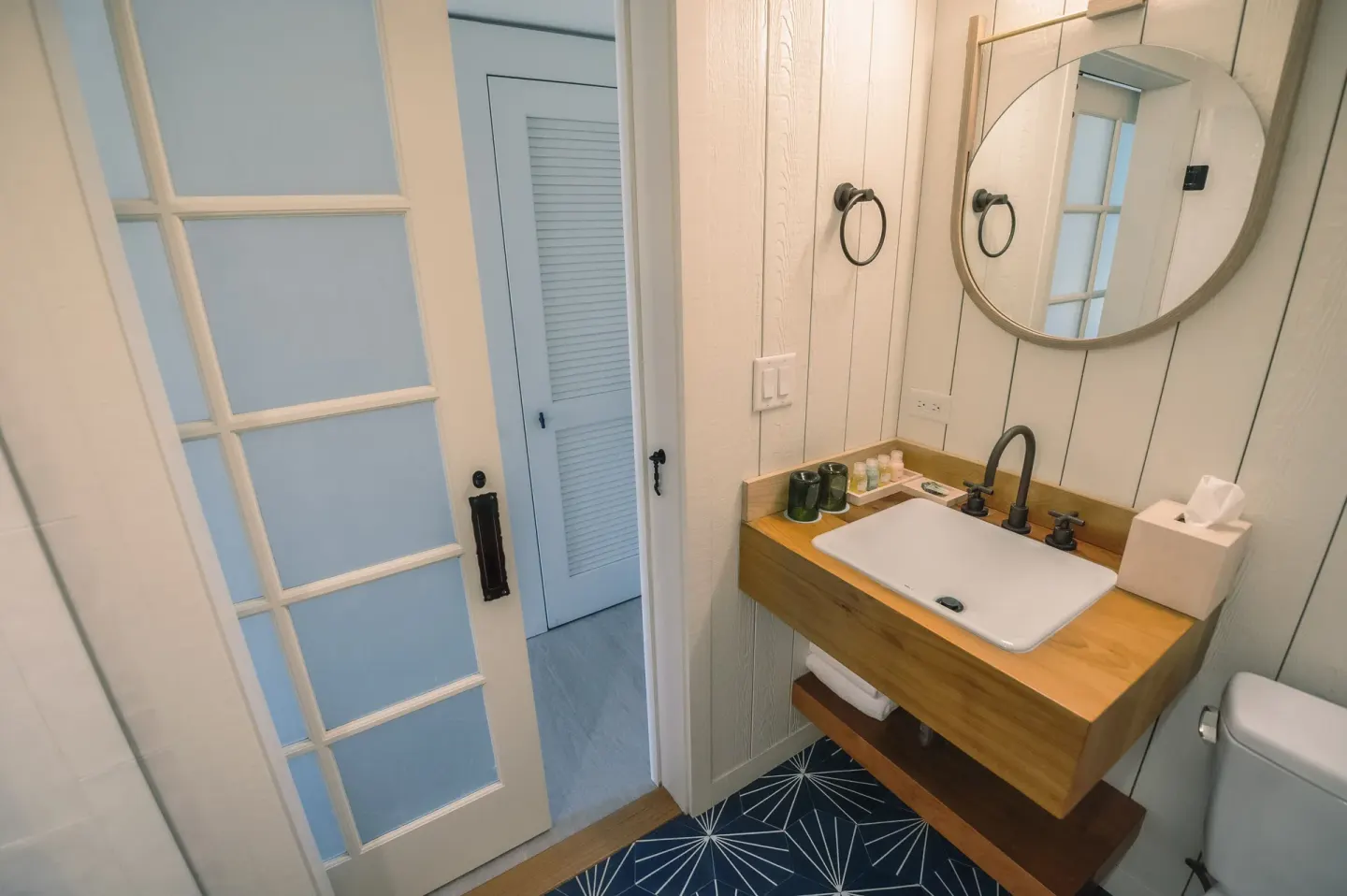 One Bedroom Suite bathroom vanity with round mirror at Surfjack Hotel & Swim Club.