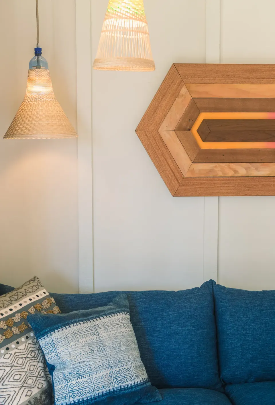One Bedroom Suite blue sofa with woven pendant lights at Surfjack Hotel & Swim Club.