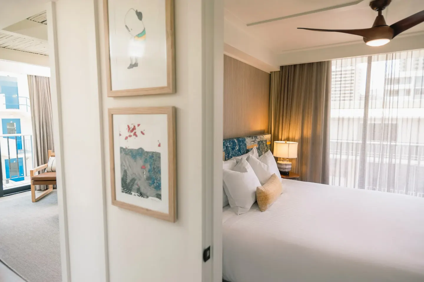 Bedroom seen through a doorway with adjoining living area at Surfjack Hotel & Swim Club.