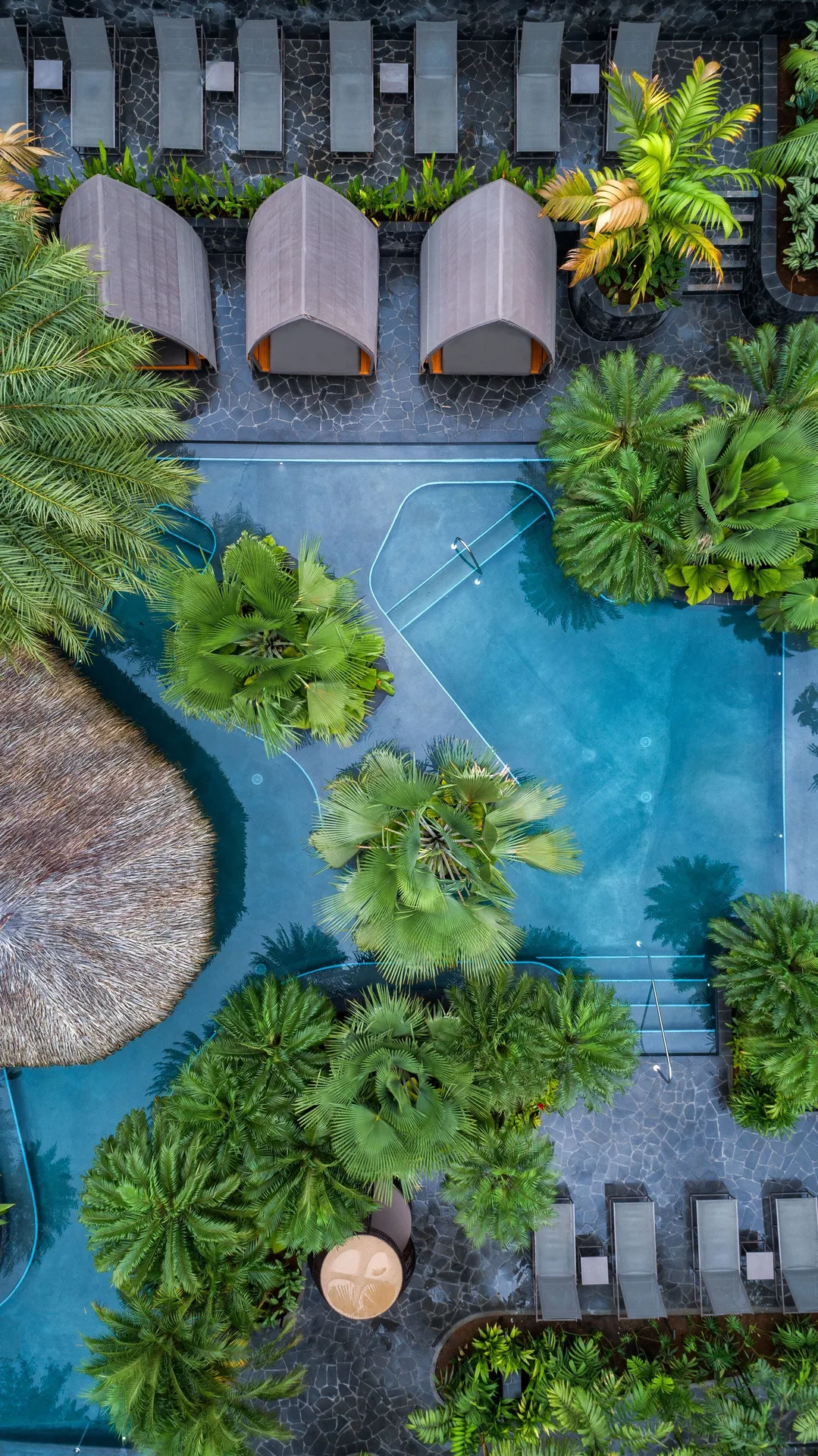 Aerial view of resort pool with cabanas and palm islands at Tabacón Thermal Resort & Spa