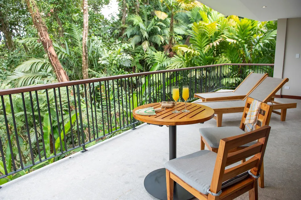 Balcony seating with lounge chairs and rainforest view at Tabacón Thermal Resort & Spa