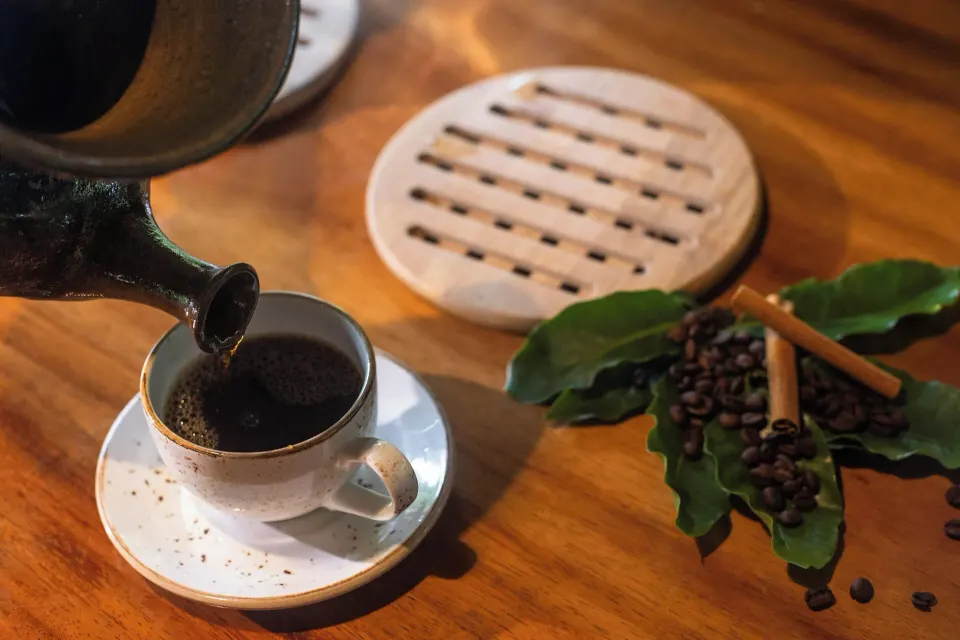 Close-up of coffee being poured into a cup with beans and cinnamon at Tabacón Thermal Resort & Spa