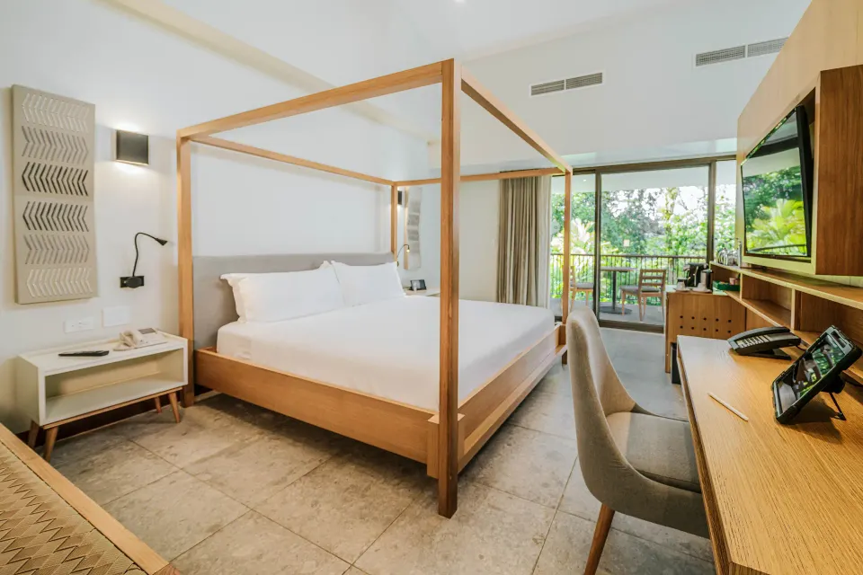 Four-poster king bed and desk in a guest room at Tabacón Thermal Resort & Spa.