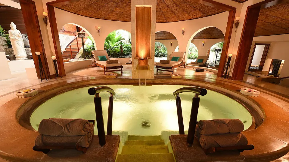 Circular indoor whirlpool surrounded by lounge seating in the spa at Tabacón Thermal Resort & Spa