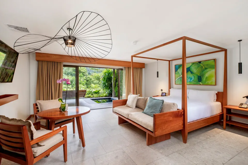 Junior suite with four-poster bed, seating area and patio pool at Tabacón Thermal Resort & Spa.