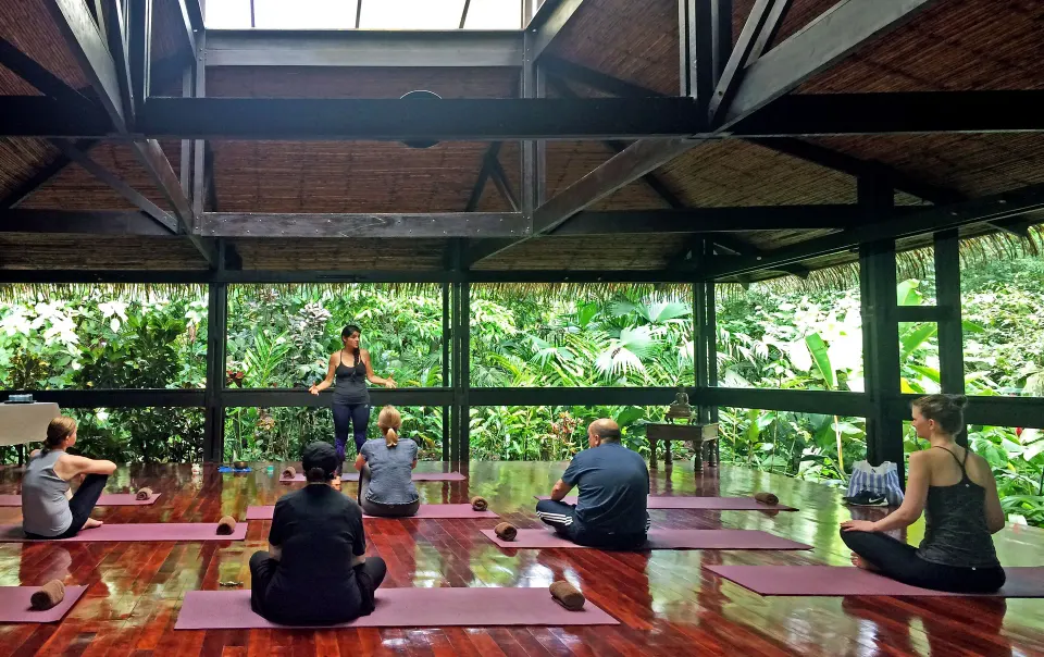 Group yoga class in an open-air studio surrounded by rainforest at Tabacón Thermal Resort & Spa