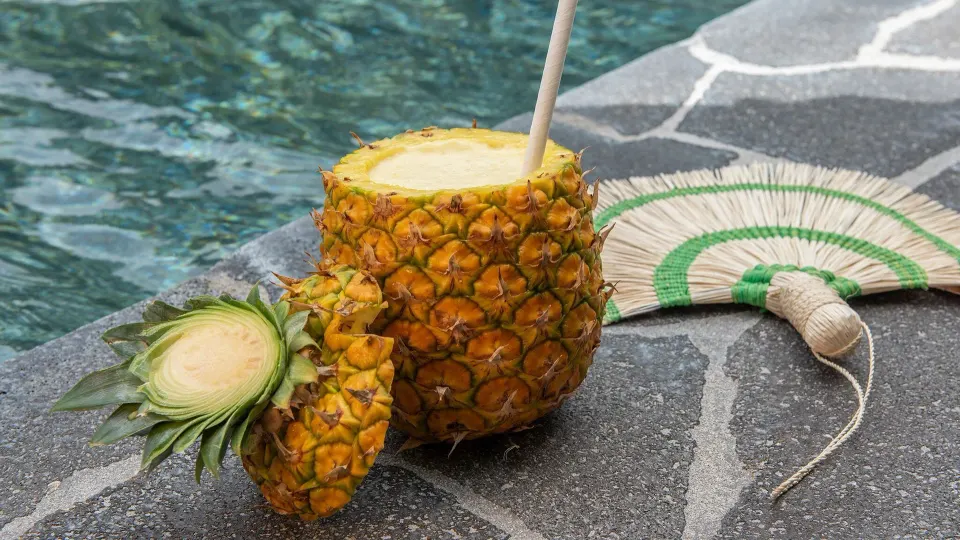 Pineapple drink served poolside on stone decking at Tabacón Thermal Resort & Spa