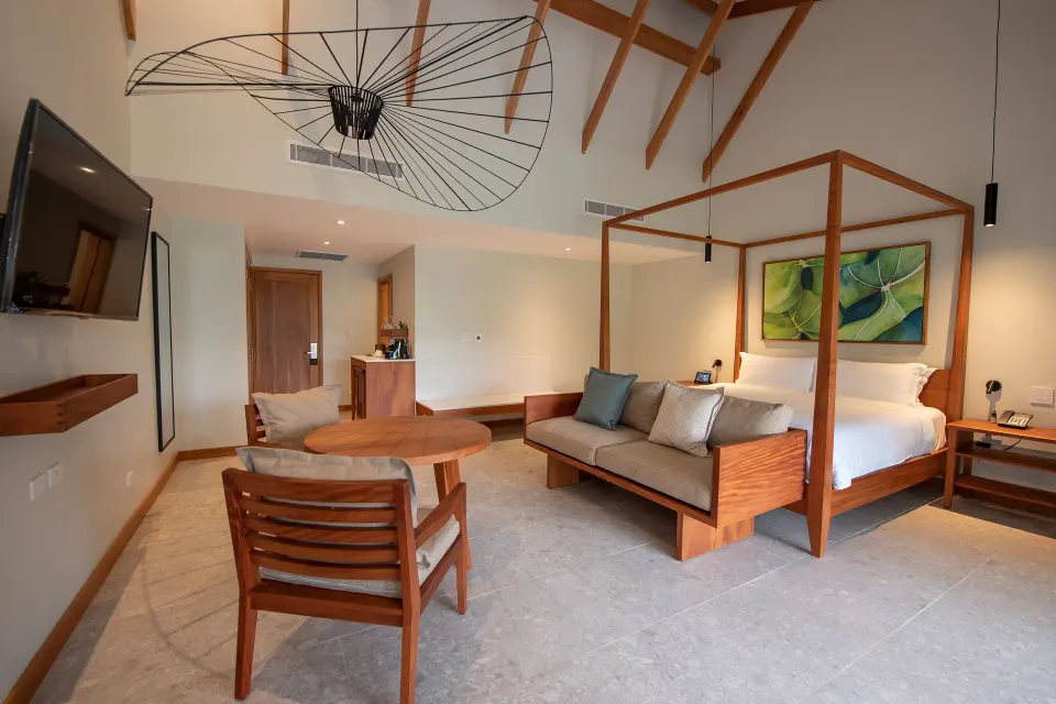 Spacious guest suite with four-poster bed and seating area at Tabacón Thermal Resort & Spa