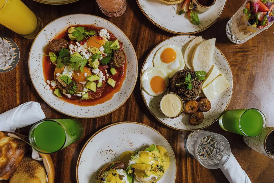 Assorted brunch plates and green juices laid out on a wooden table at Tabacón Thermal Resort & Spa