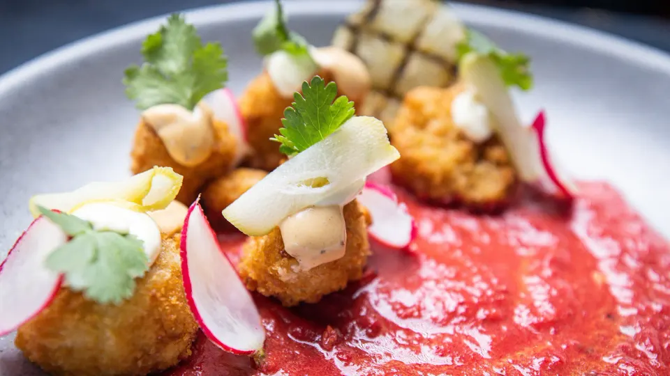Crispy fried bites with radish and red sauce on a plate at Tabacón Thermal Resort & Spa