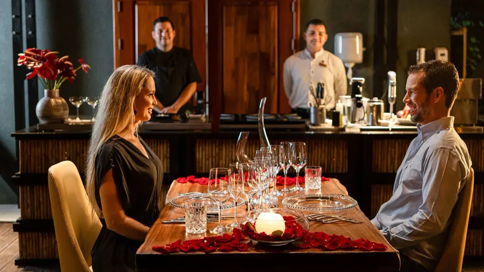 Romantic table setting with couple dining and staff behind at Tabacón Thermal Resort & Spa