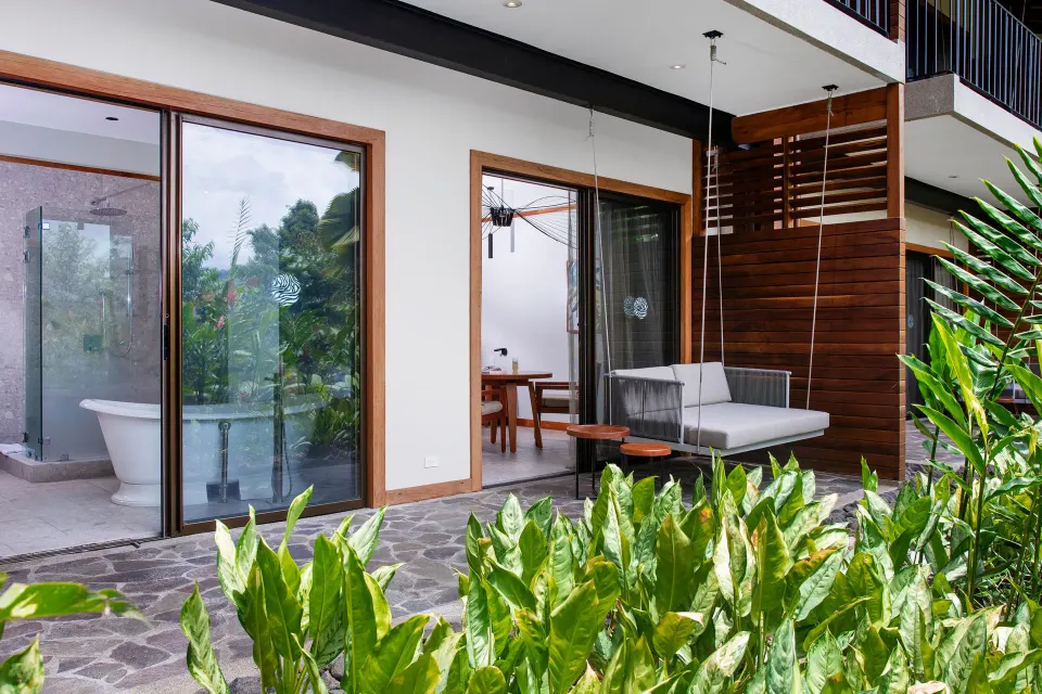 Ground-level patio with hanging daybed outside Rainforest King Bed Room at Tabacón Thermal Resort & Spa