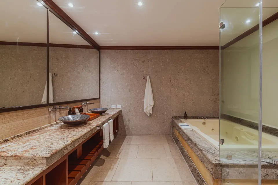 Bathroom with double sink vanity and jetted tub in a Tabacón Suite King Bed Room at Tabacón Thermal Resort & Spa