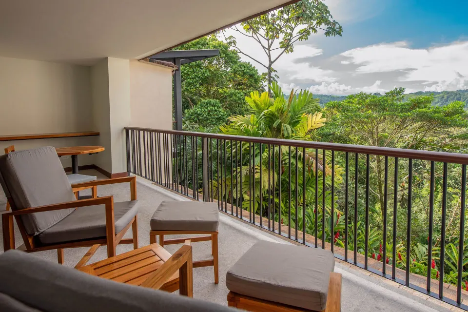 Private balcony seating overlooking rainforest views from a Tabacón Suite King Bed Room at Tabacón Thermal Resort & Spa