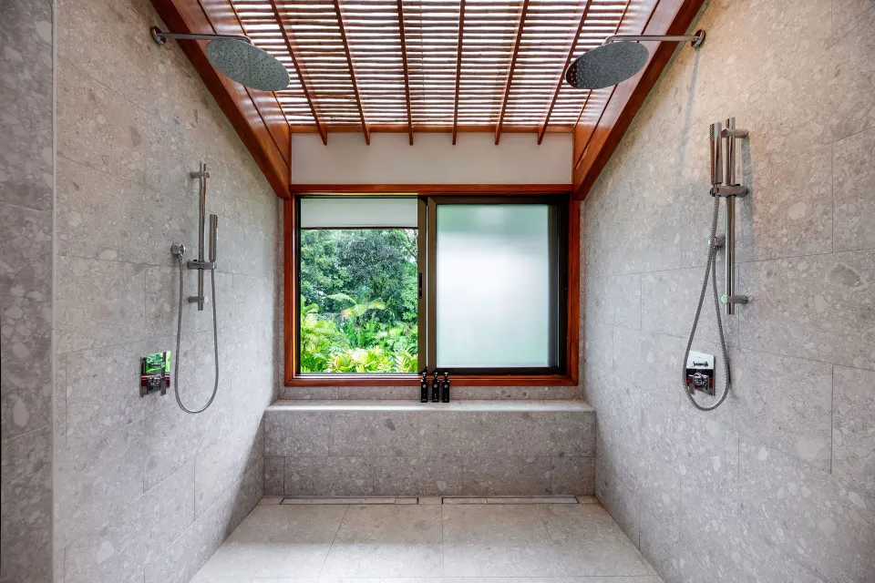 Volcano View Suite twin rain showers with garden-view window at Tabacón Thermal Resort & Spa