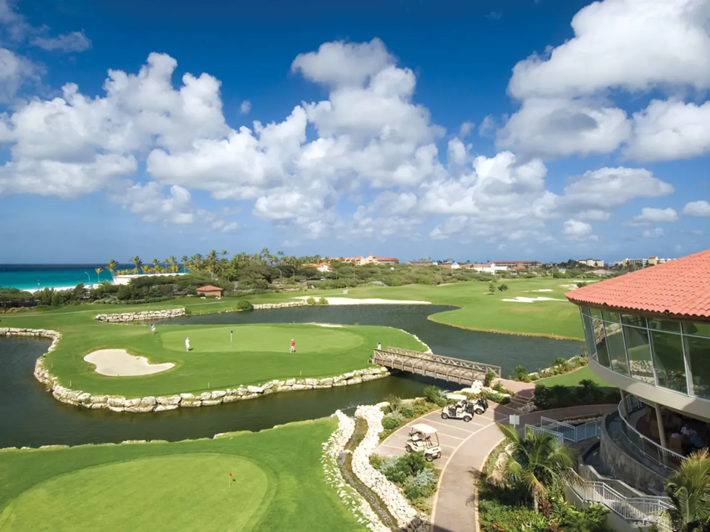 Golf course greens, water hazards and ocean views near Tamarijn Aruba.