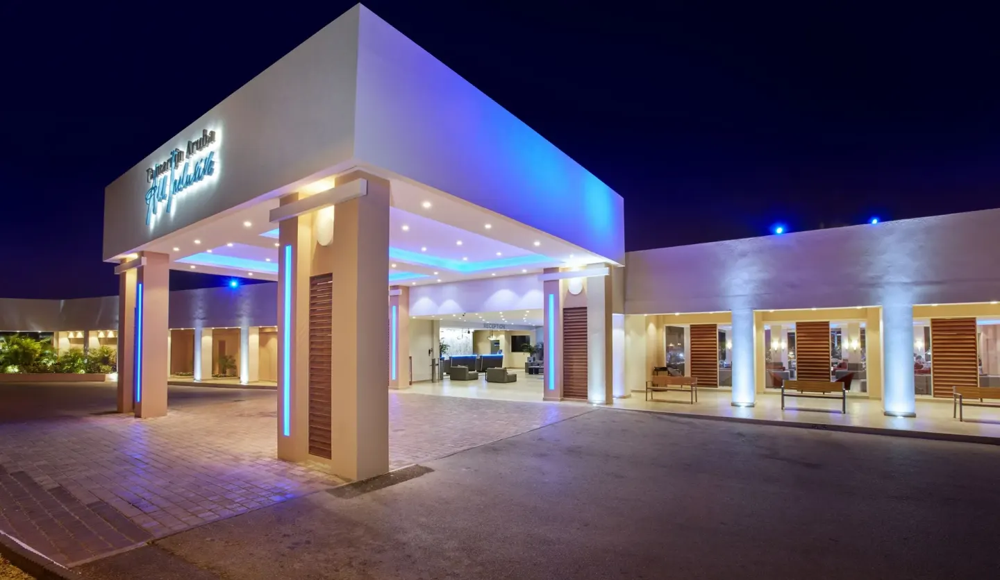 Night exterior of the illuminated entrance canopy at Tamarijn Aruba.