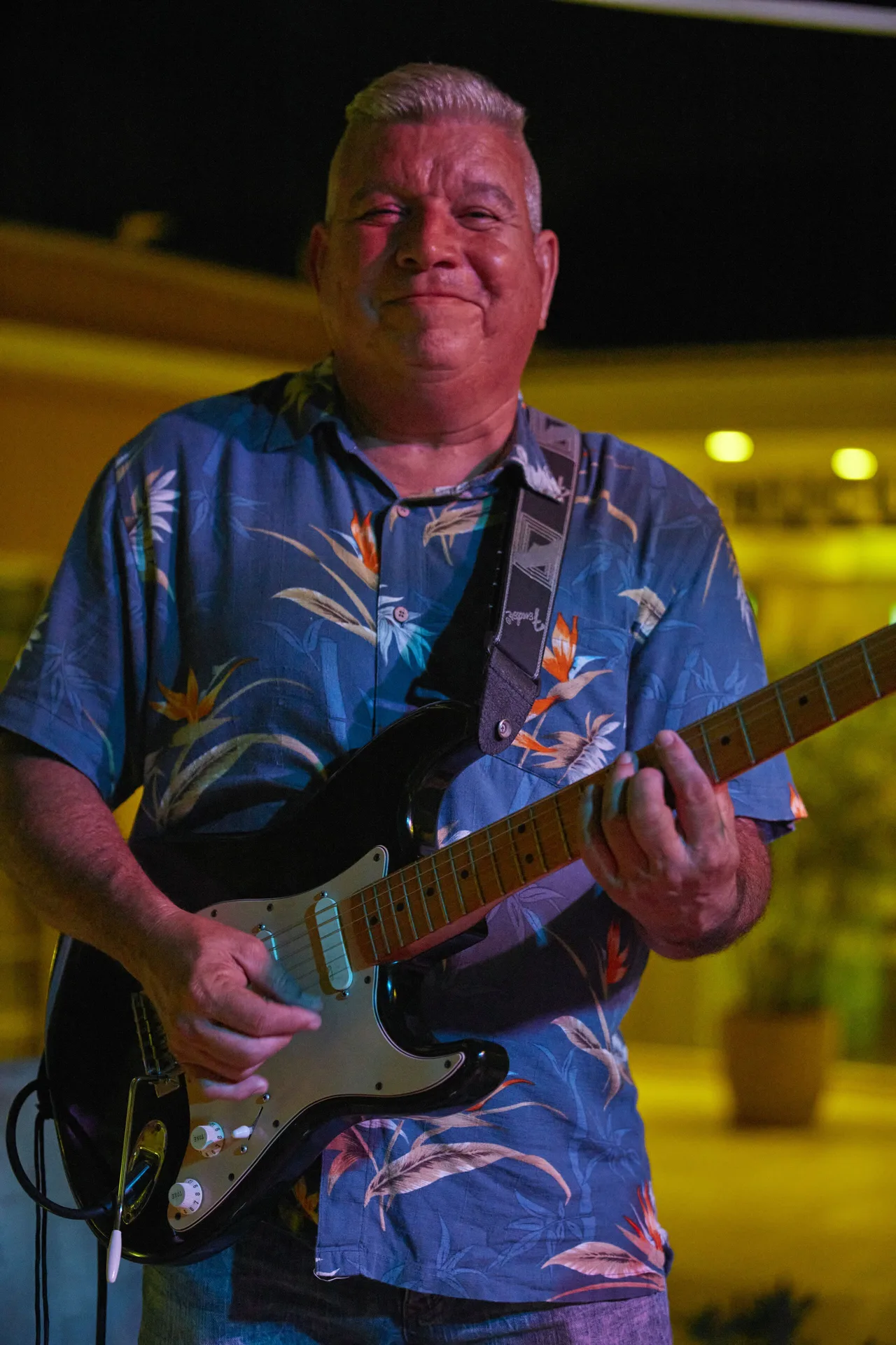 A guitarist performing at night during live entertainment at Tamarijn Aruba.