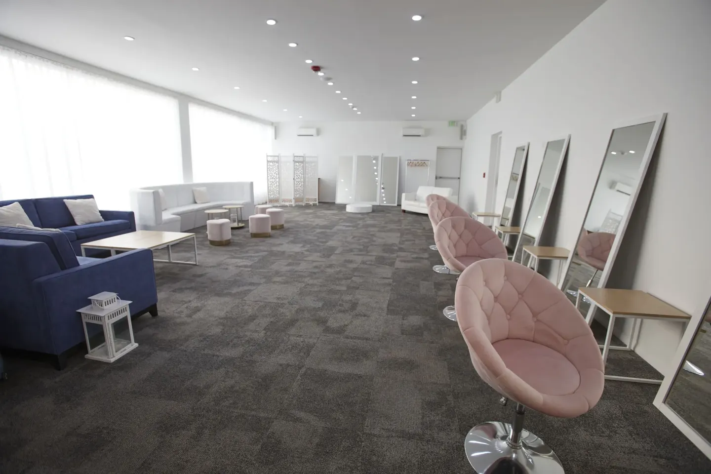 Bright salon-style room with mirrors and pink chairs at Tamarijn Aruba.
