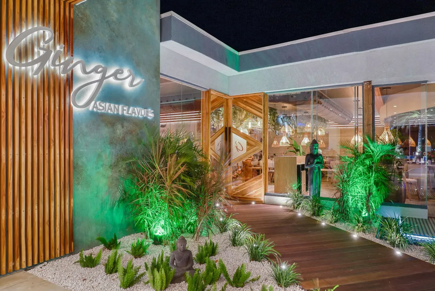 Ginger entrance with illuminated sign and landscaping at Tamarijn Aruba.