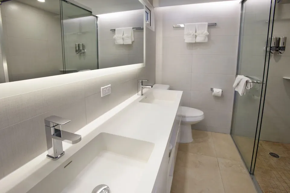 Deluxe Oceanfront bathroom with double vanity and glass shower at Tamarijn Aruba.