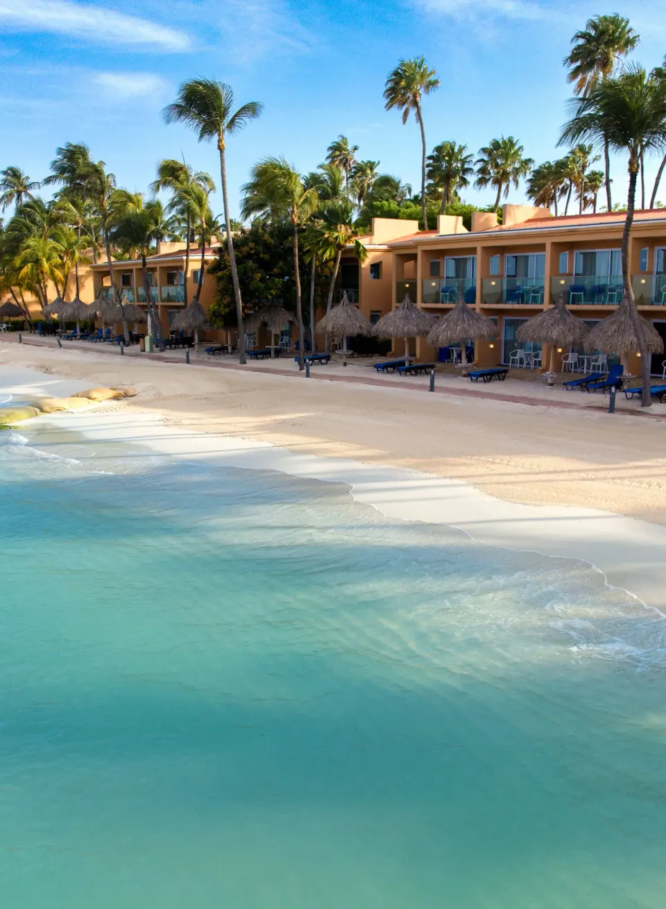Beachfront guest room buildings beside the ocean at Tamarijn Aruba.