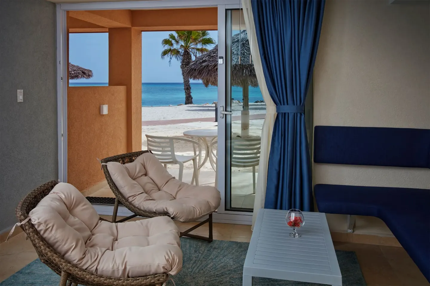 Deluxe Oceanfront seating area with patio and beach view at Tamarijn Aruba.