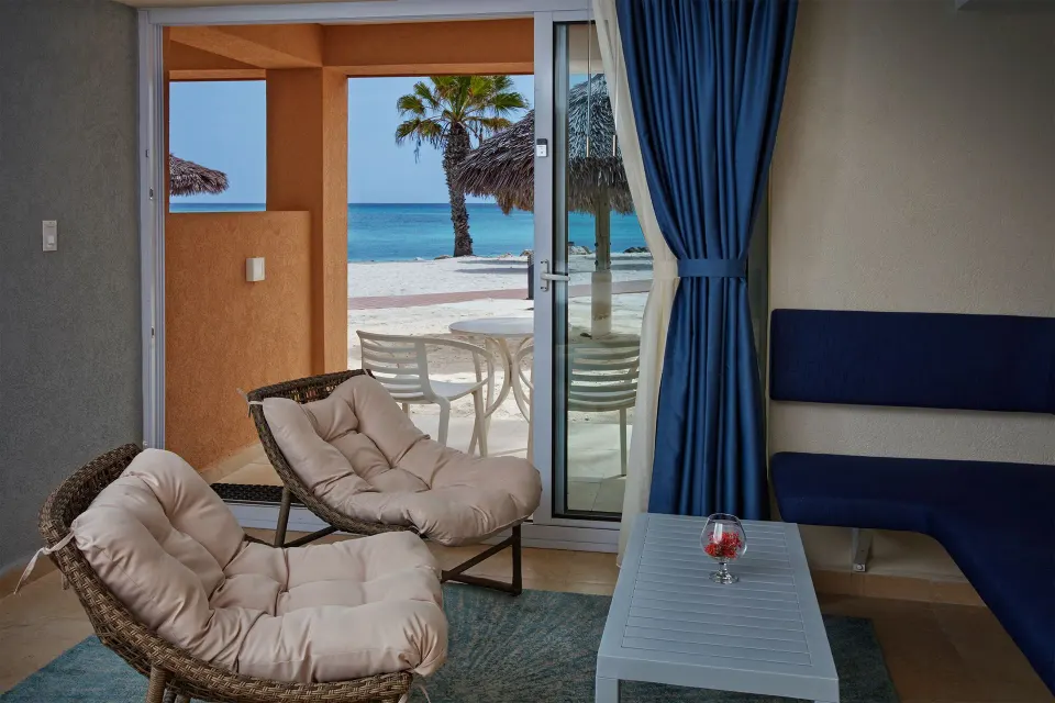 Deluxe Oceanfront seating area with patio and beach view at Tamarijn Aruba.