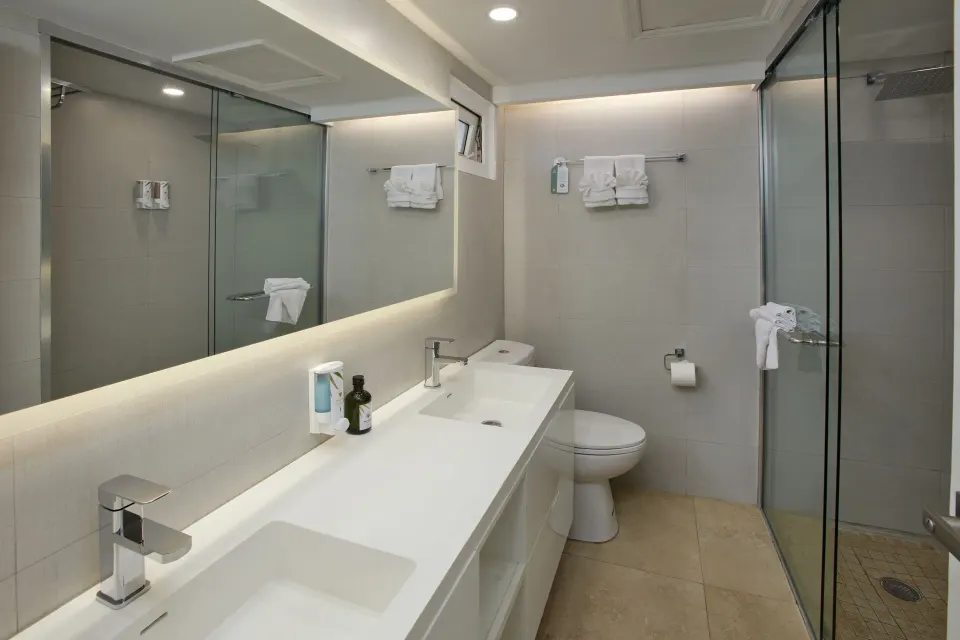 Premium Oceanfront Room bathroom with double vanity and glass shower at Tamarijn Aruba.
