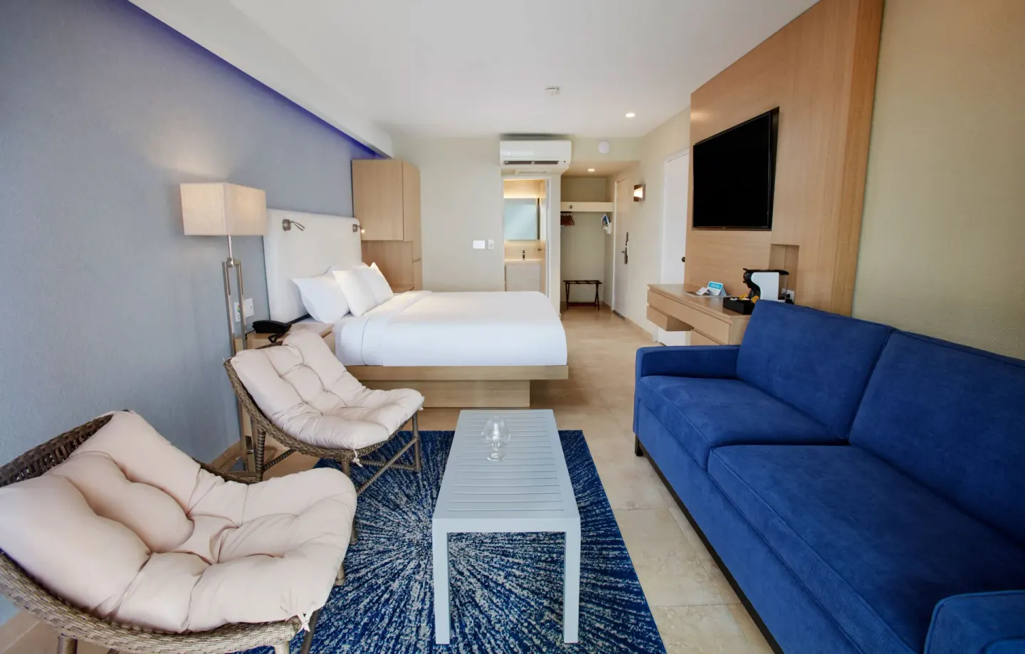 Premium Oceanfront Room with king bed, sofa, and lounge chairs at Tamarijn Aruba.