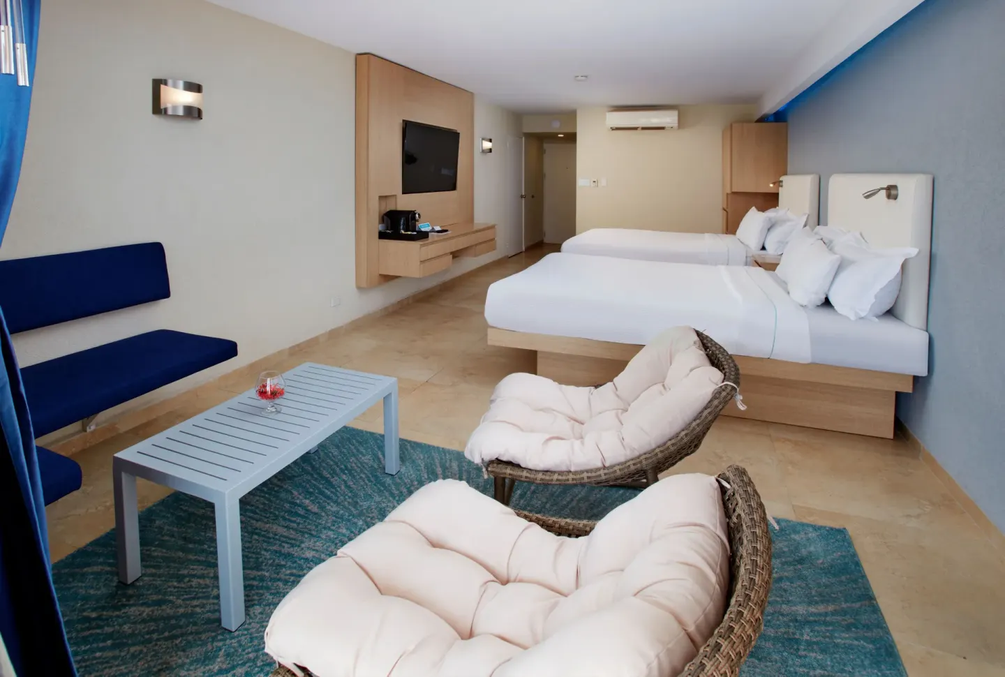 Premium Oceanfront Room seating area and two beds at Tamarijn Aruba.