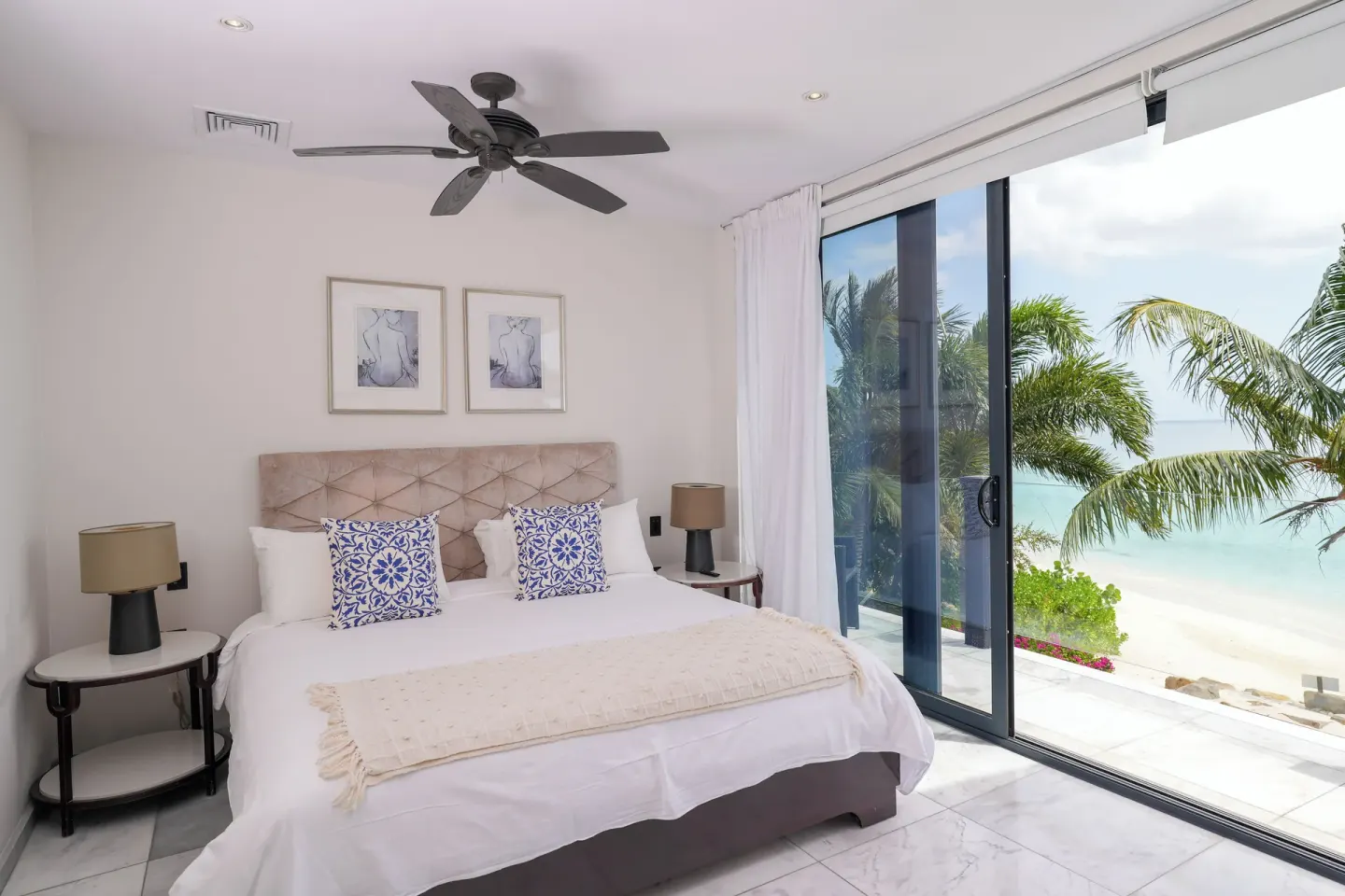 Beach-view king bedroom with sliding glass doors at Tamarind Hills Resort & Villas.