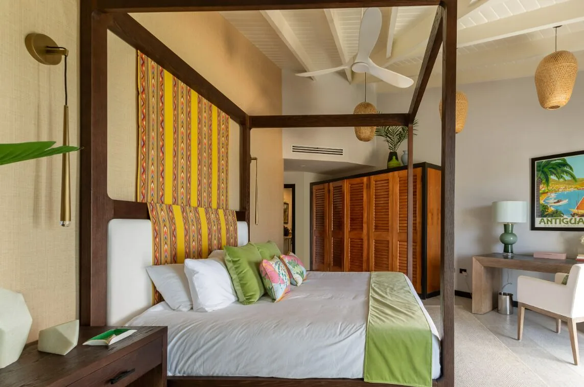 Four-poster king bed guest room with colorful headboard at Tamarind Hills Resort & Villas.