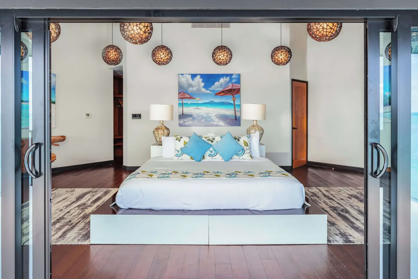 King bed guest room with beach artwork at Tamarind Hills Resort & Villas.