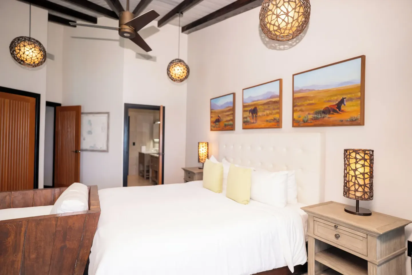 King bed with woven lamps in a guest room at Tamarind Hills Resort & Villas.