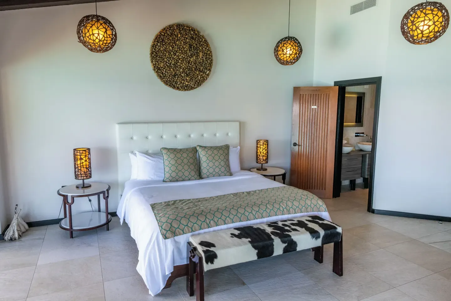 King bed guest room with woven lighting at Tamarind Hills Resort & Villas.