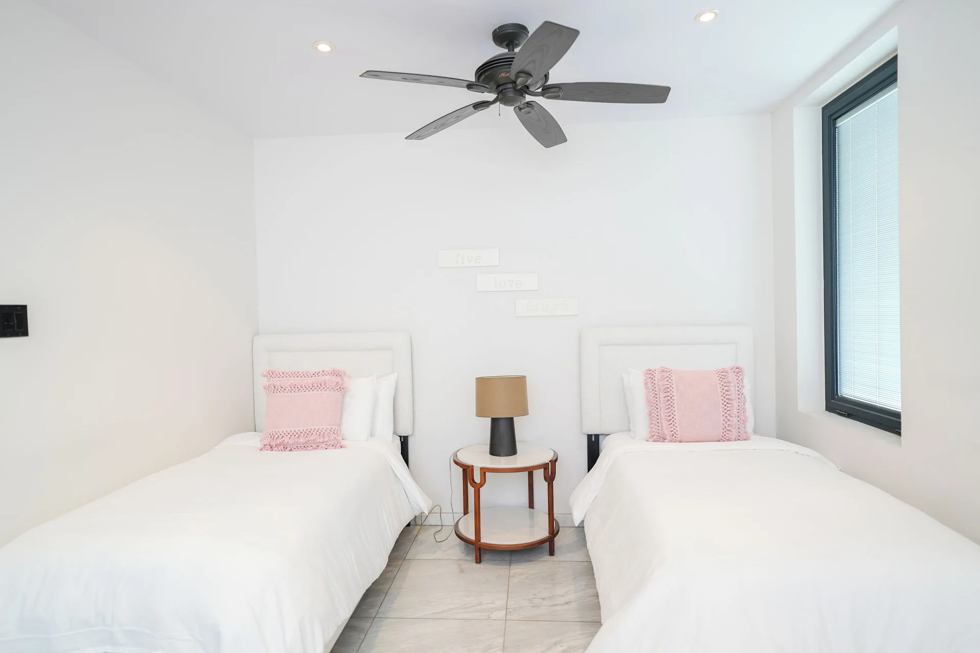 Twin beds with pink pillows in a guest room at Tamarind Hills Resort & Villas.