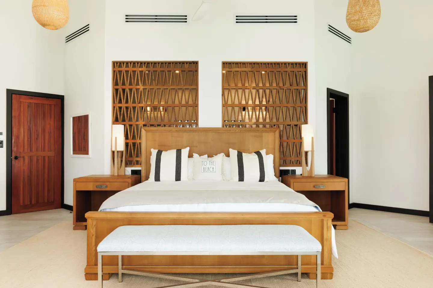 King-bed guest room with wood lattice headboard wall at Tamarind Hills Resort & Villas.