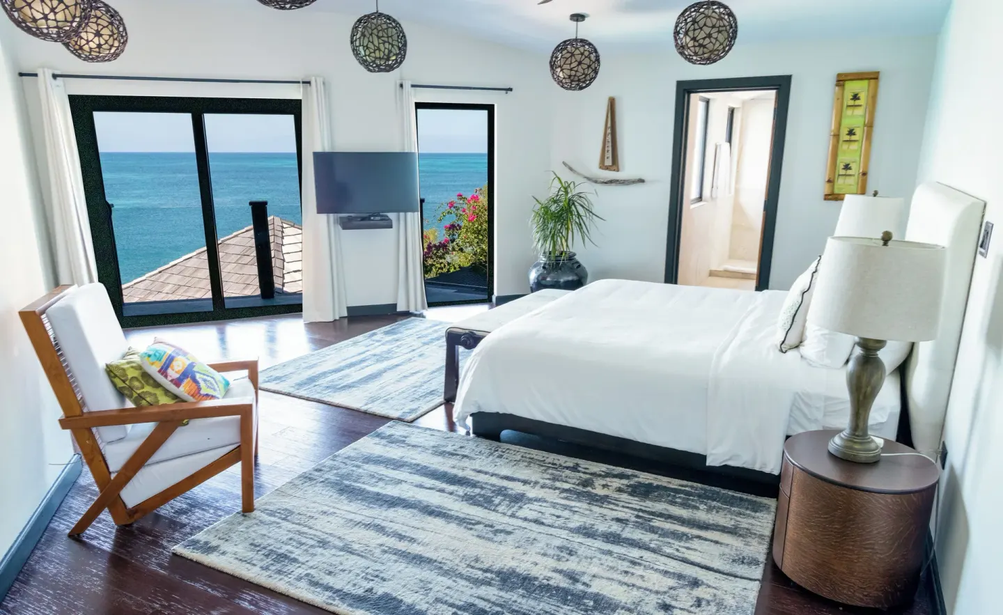 Ocean-view king-bed guest room with dark wood floor at Tamarind Hills Resort & Villas.