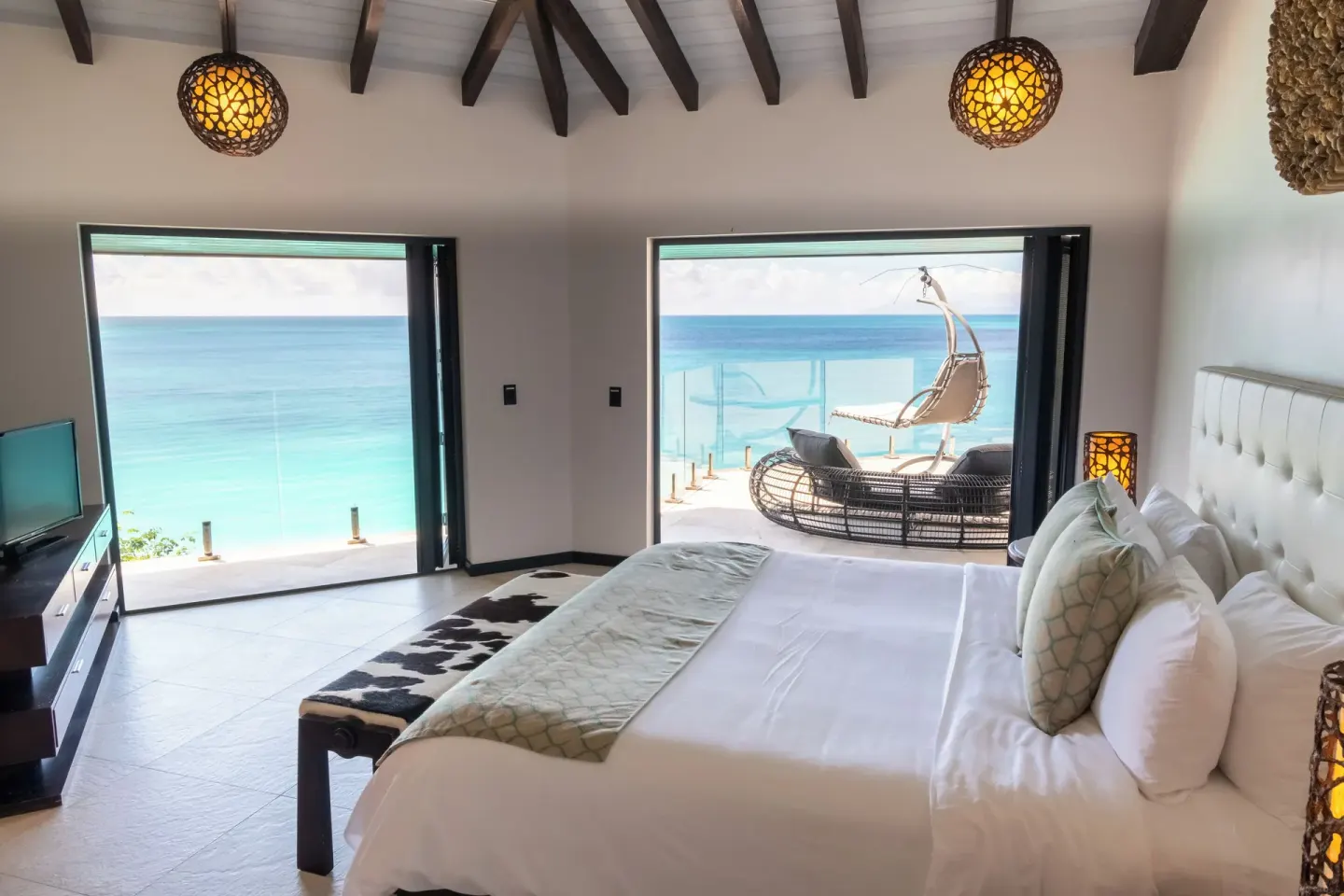 King bedroom opening to an ocean terrace at Tamarind Hills Resort & Villas.