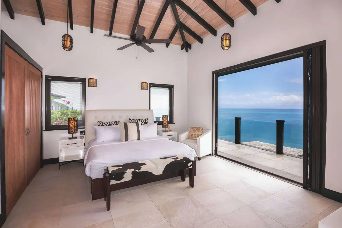 King bed guest room with ocean-facing balcony at Tamarind Hills Resort & Villas.