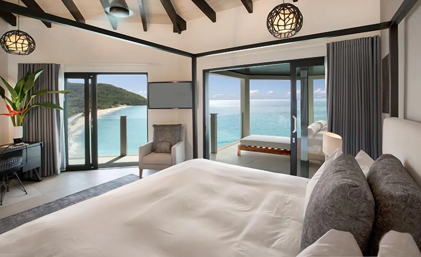 Ocean view king bedroom with terrace doors at Tamarind Hills Resort & Villas.