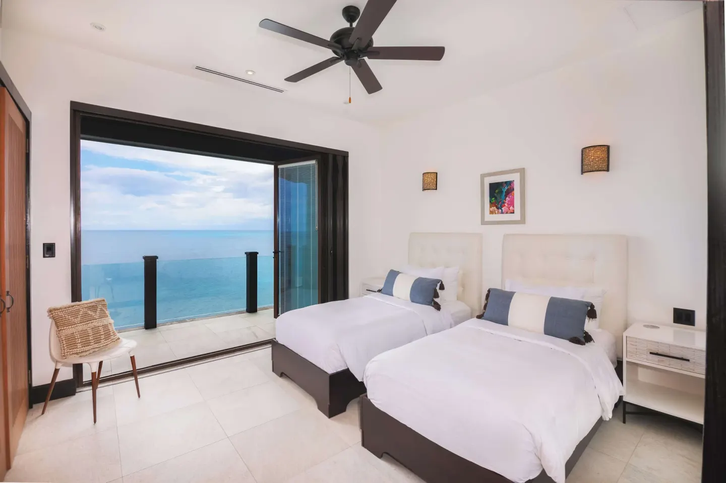 Twin bed guest room with sliding doors to an ocean balcony at Tamarind Hills Resort & Villas.