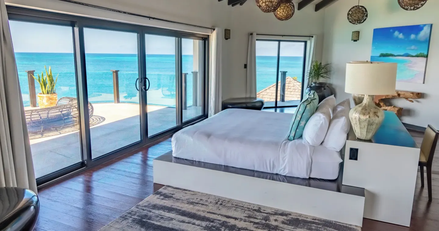 Oceanfront king bedroom with sliding glass doors at Tamarind Hills Resort & Villas.