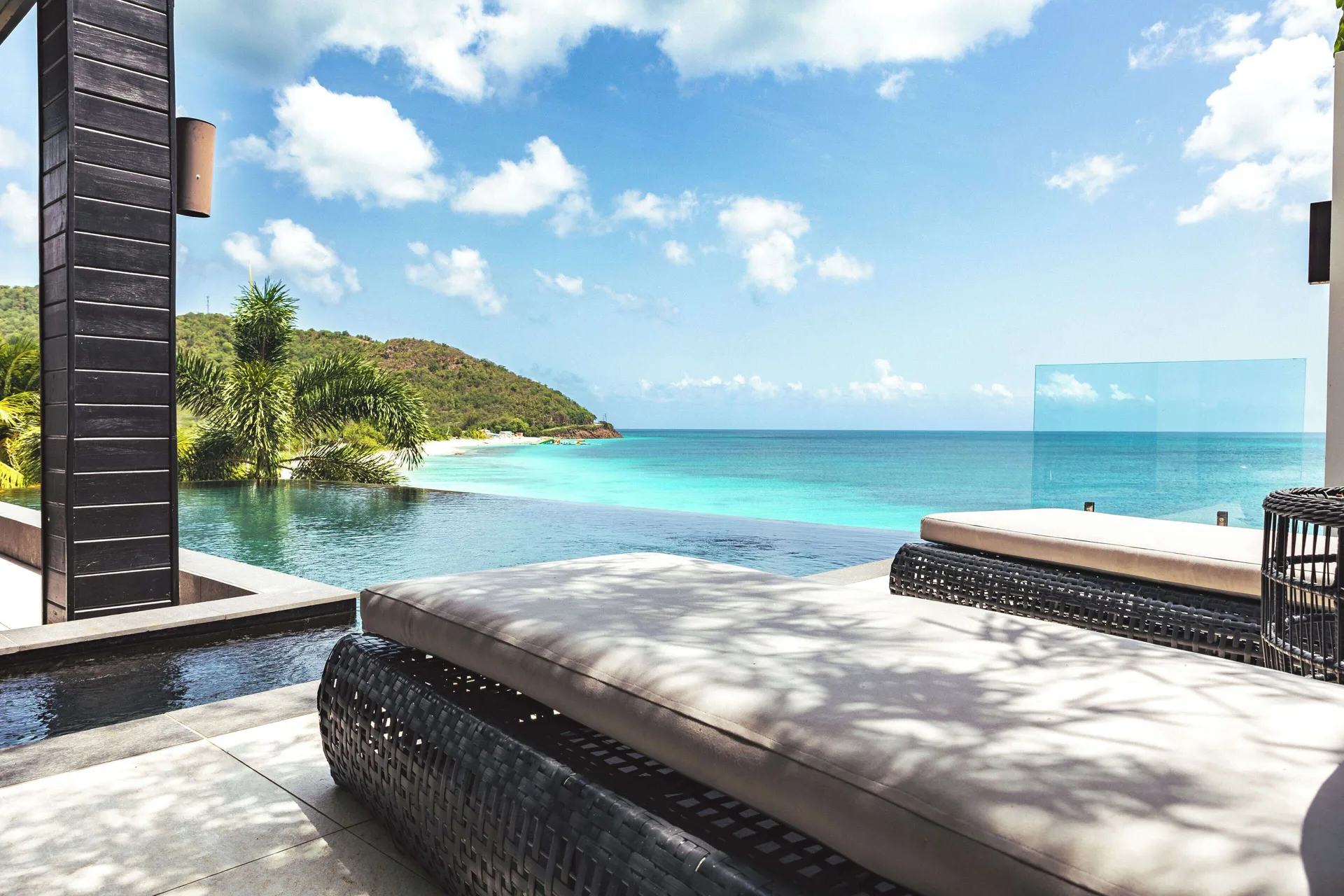 Poolside loungers facing the turquoise sea at Tamarind Hills Resort & Villas.