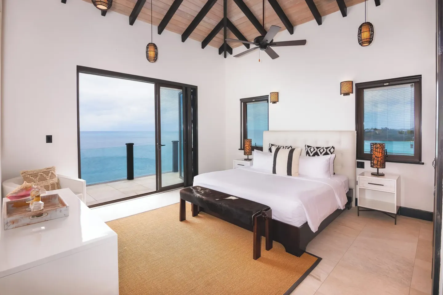 King bed guest room with vaulted ceiling and sea-view balcony at Tamarind Hills Resort & Villas.